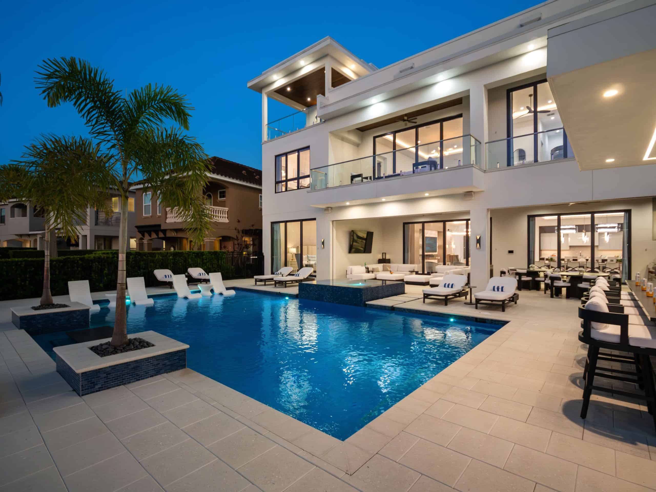 Modern pool area with palm trees and contemporary outdoor furniture in North Village, Celebration