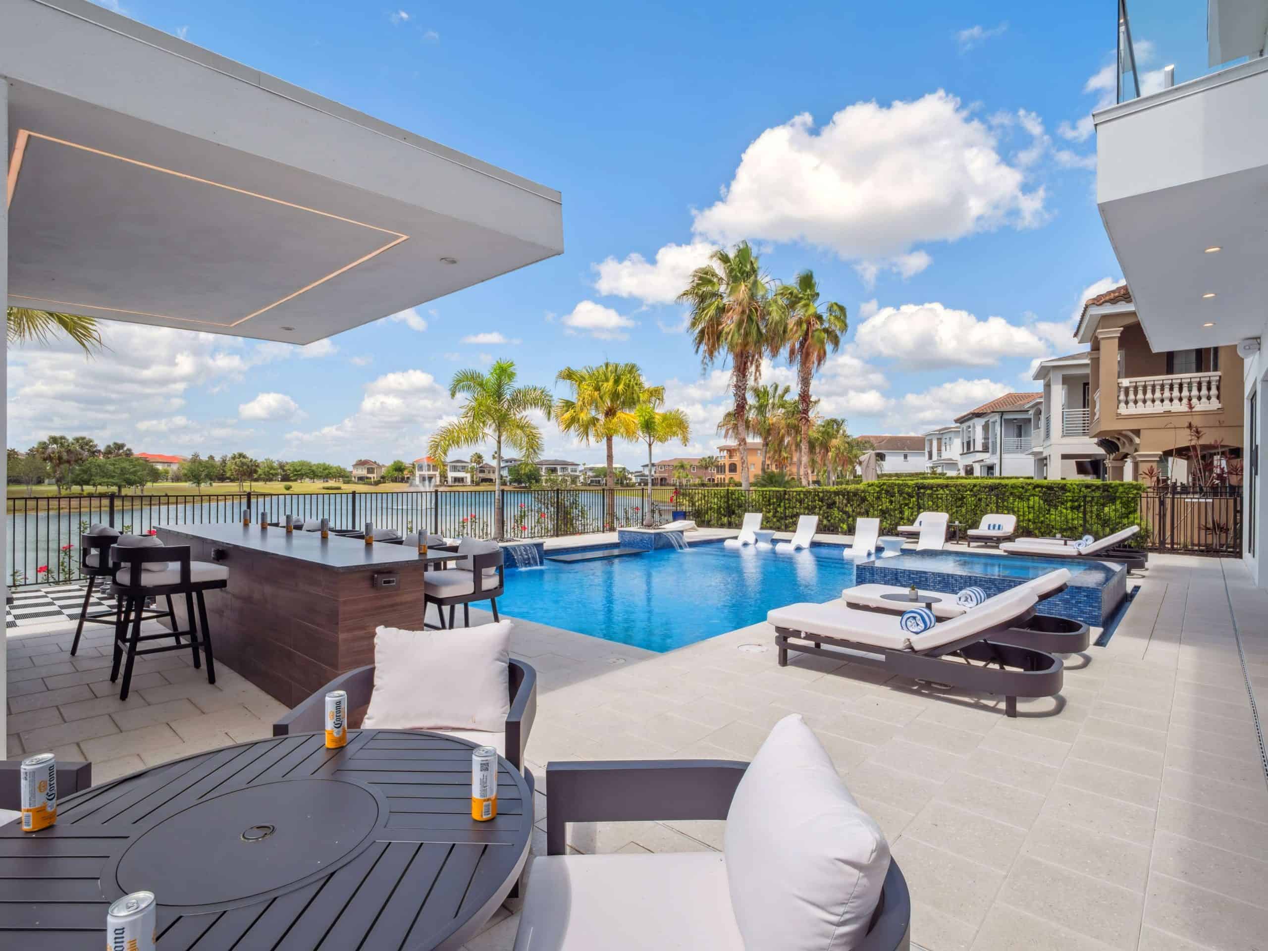 Outdoor pool area with lounge chairs, lush landscaping, and water views in Downtown Titusville