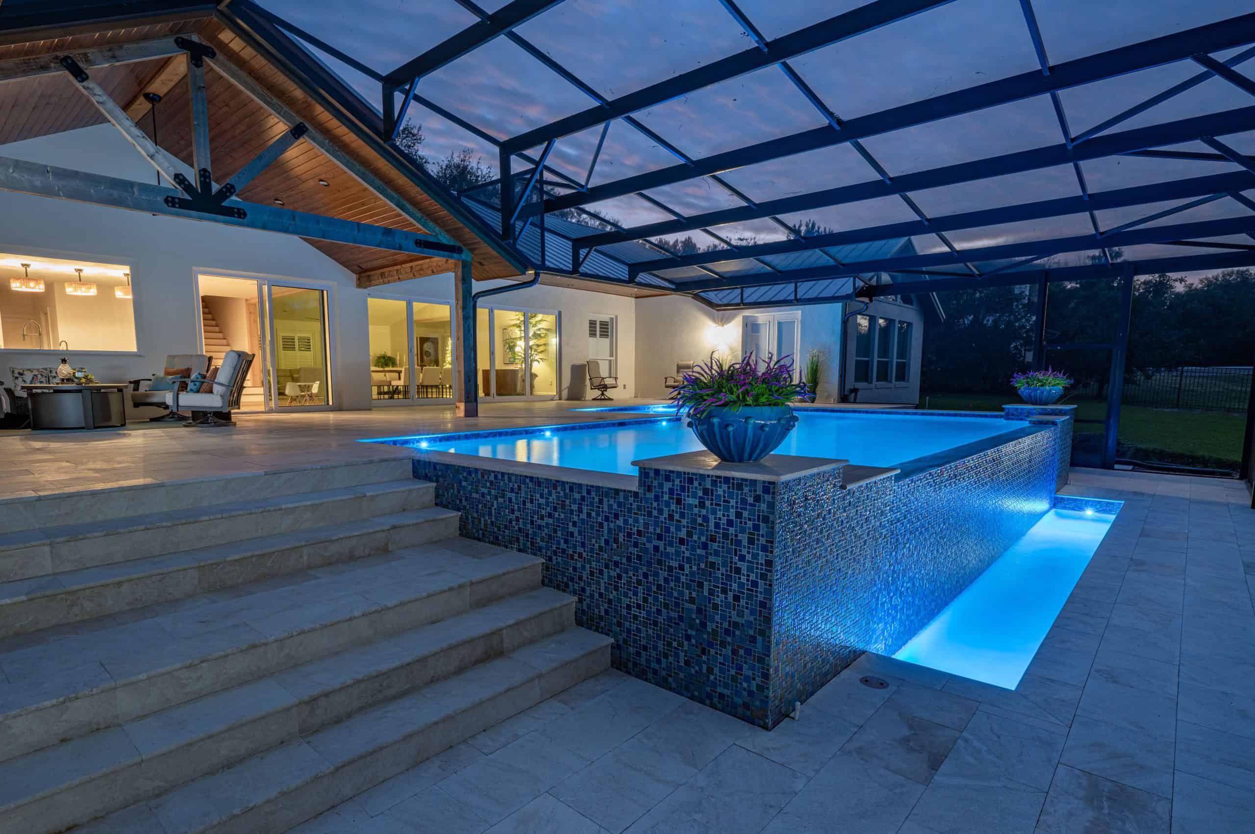 DSC_2083-Edit Elegant custom-designed pool with infinity edge, lush landscaping, and waterfront view.