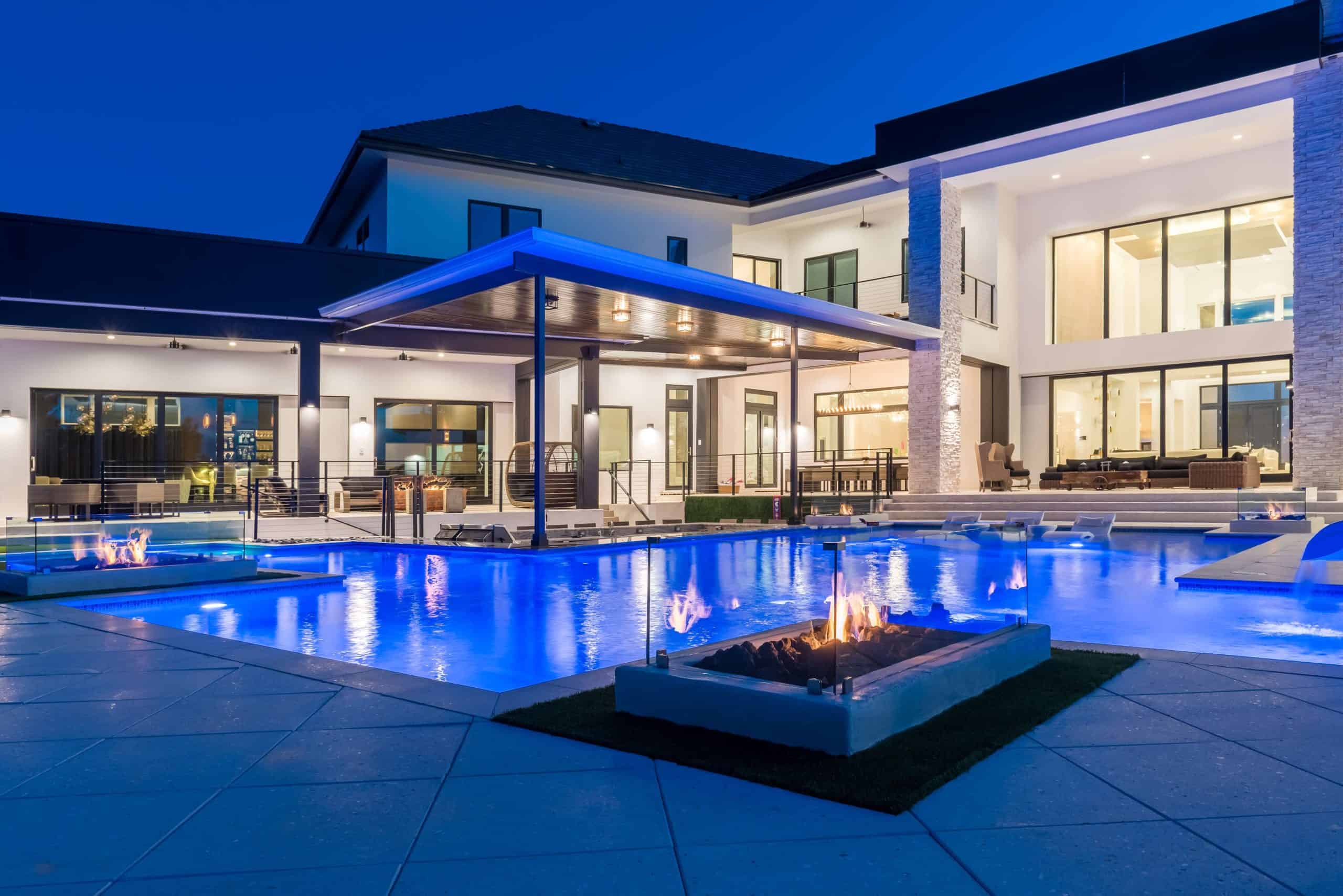 Contemporary backyard pool with fire features and outdoor lounge area at night in Ormond Beach, Volusia County FL