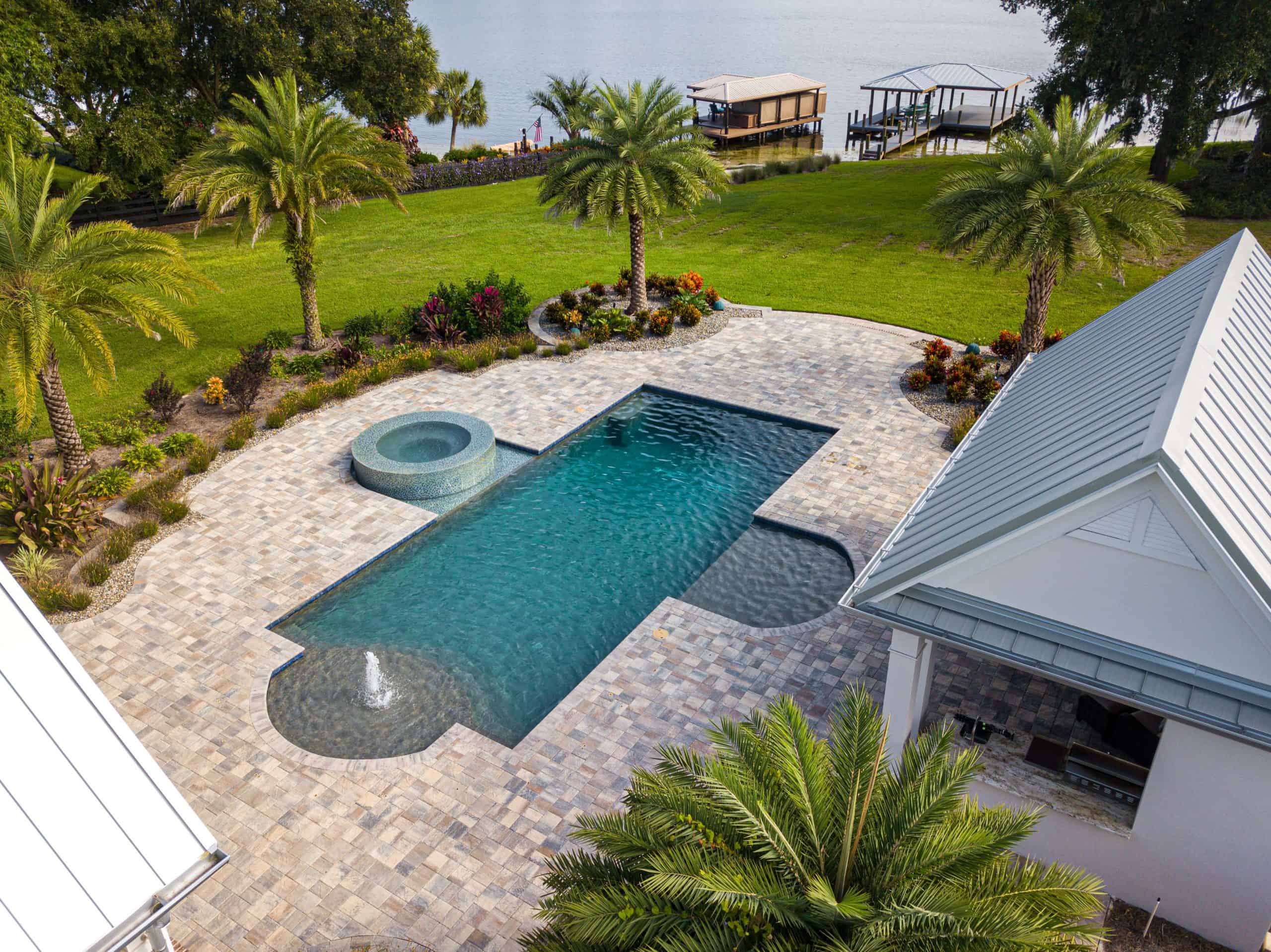 Backyard pool with spa, water feature, palm trees, and landscaped garden in Reunion Resort