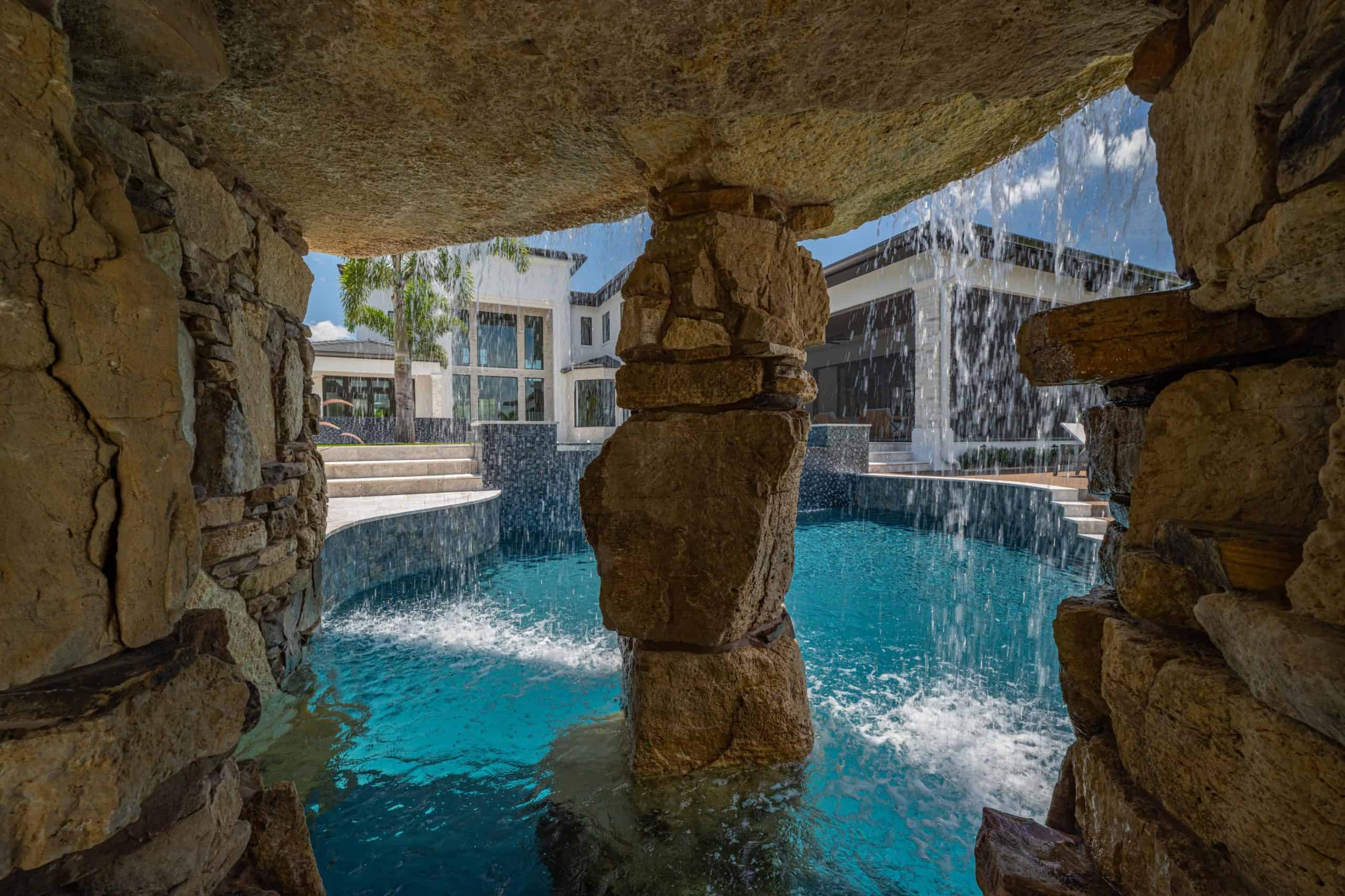 Luxurious backyard pool featuring rock formations, waterfalls, and modern design elements in Twenty Mile & Crosswater