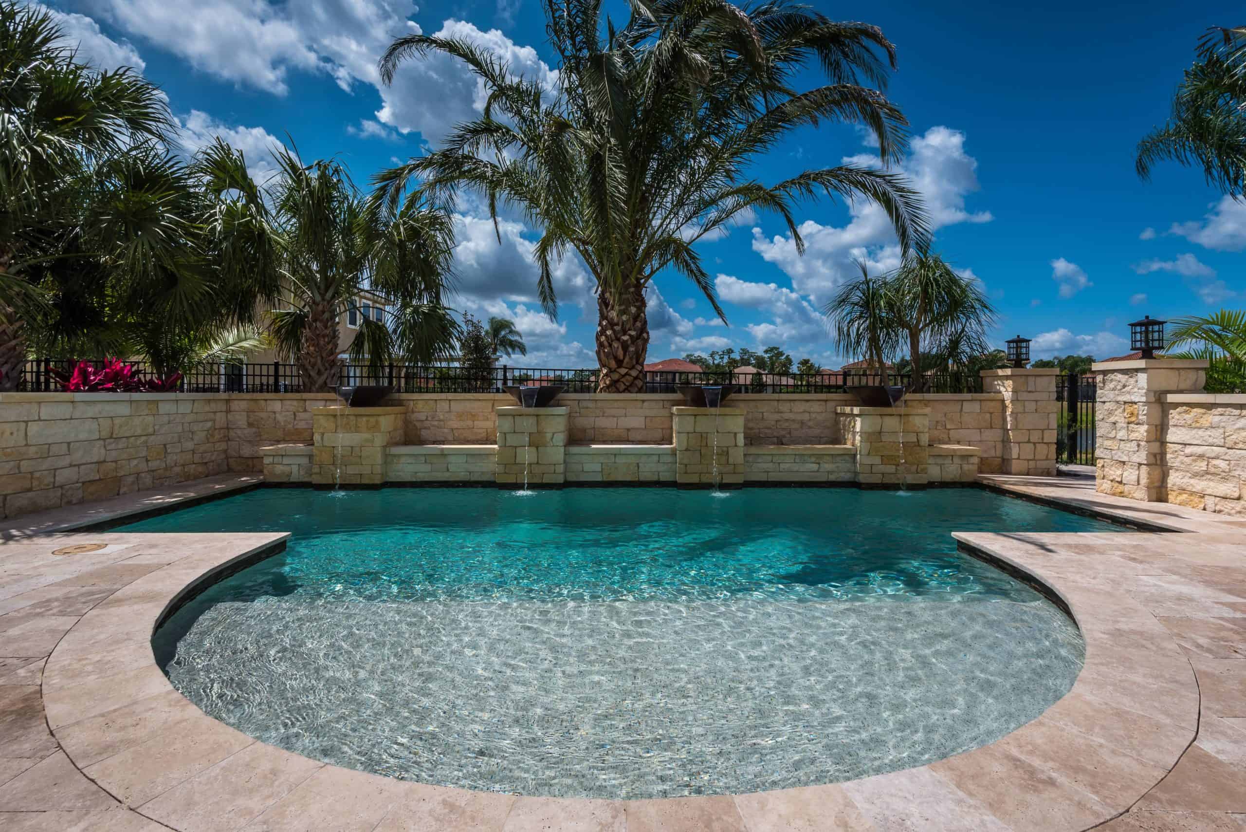 Stunning custom-designed luxury swimming pool with palm trees and stone accents in a backyard oasis in Sawgrass and The Plantion Ponte Vedra Beach