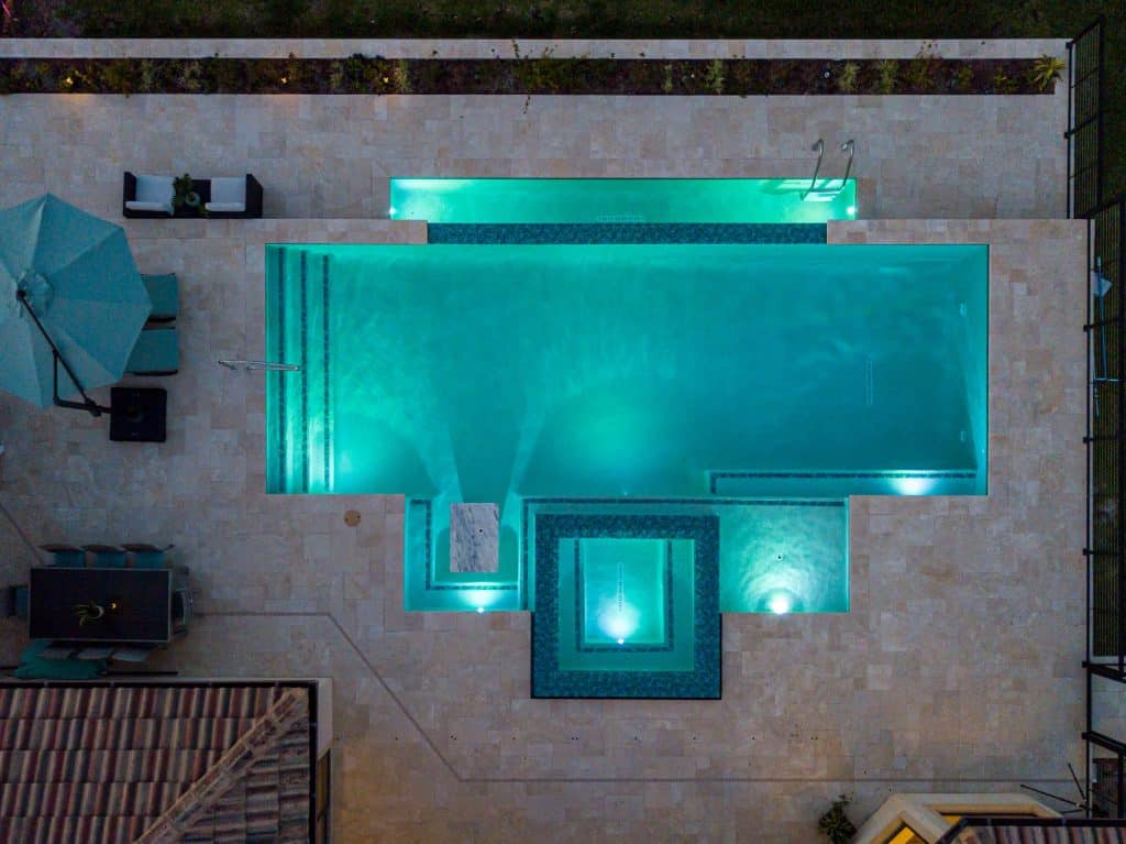 Luxury infinity edge pool with a lighting feature at night in Florida