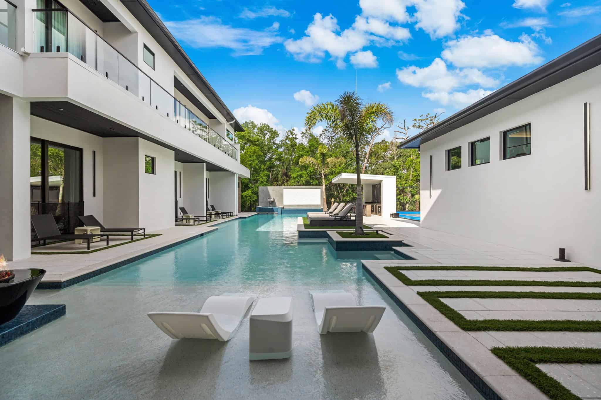 Contemporary swimming pool with sleek design, lounge seating, and lush landscaping in Downtown Kissimmee