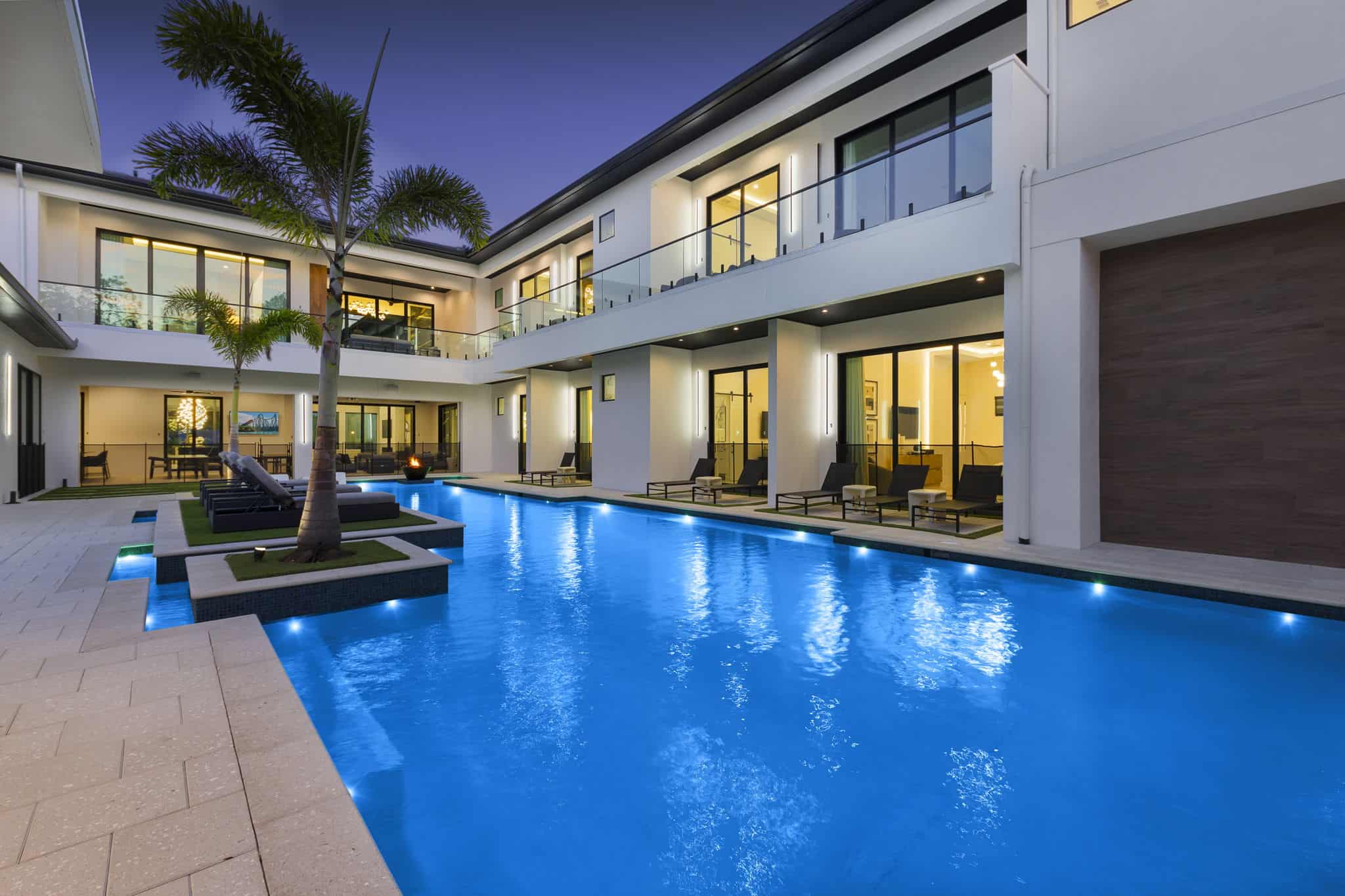 Illuminated backyard pool with custom design and outdoor seating at dusk in Mainland Neighborhoods, Daytona Beach