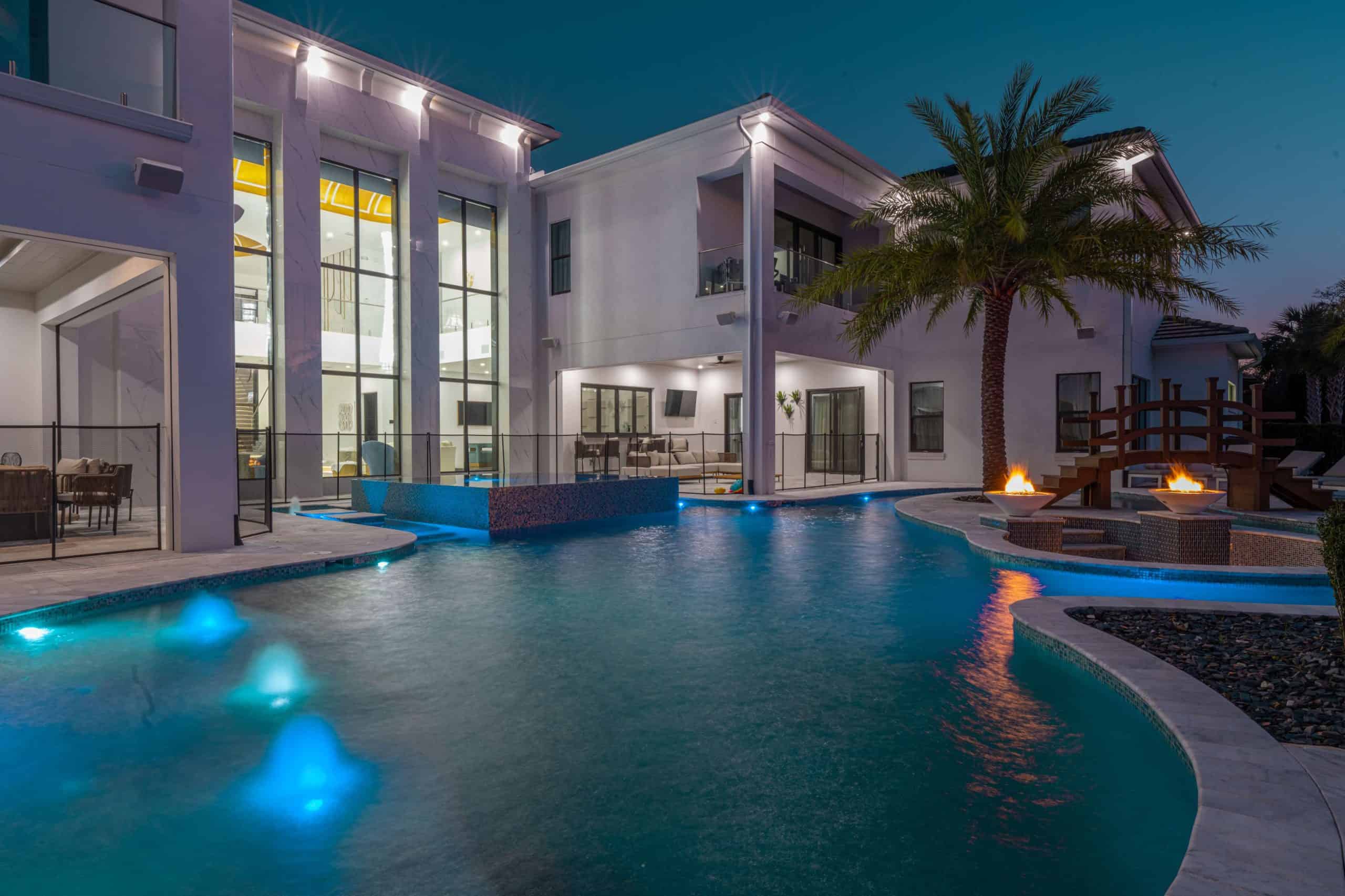 TungPhotography32 Aerial view of a custom-designed luxurious pool with lounge chairs, palm trees, and a spa area.