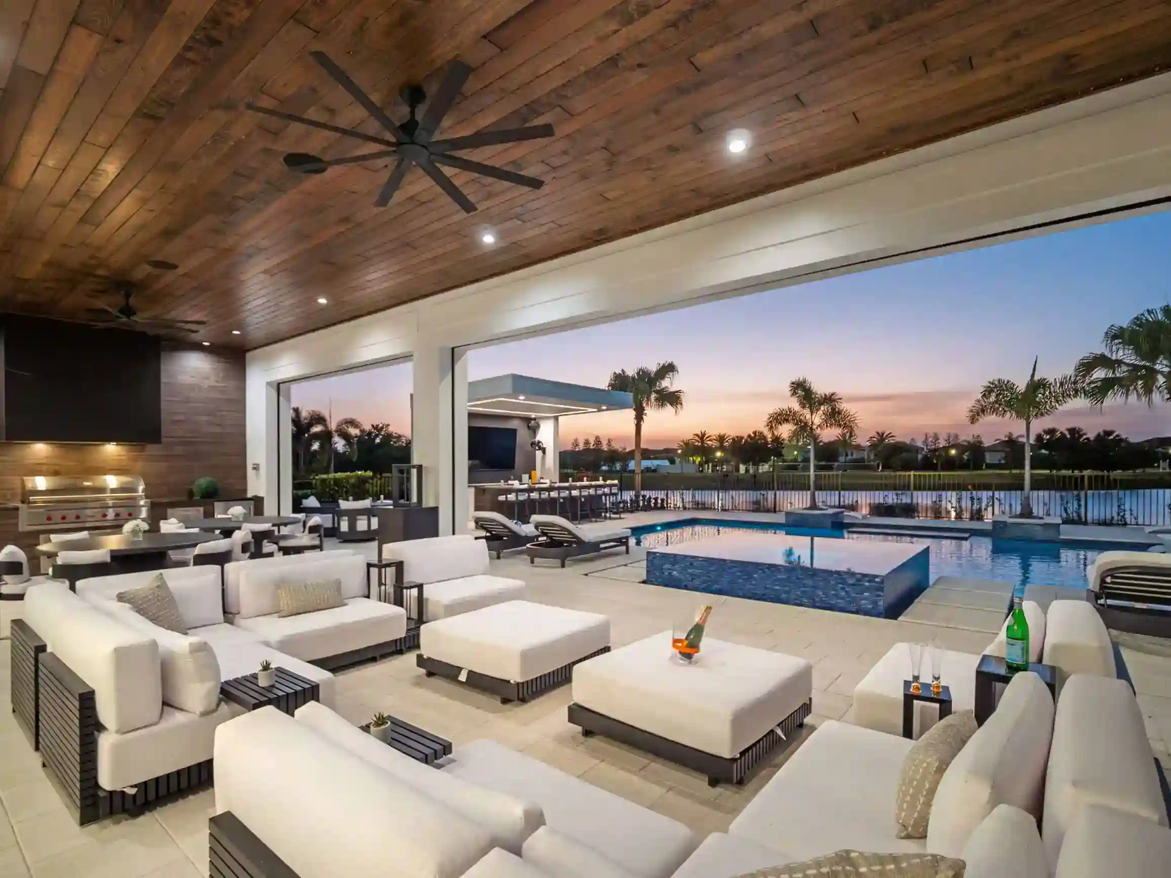 Upscale outdoor pool area with seating and modern amenities at sunset in Carisbrooke, Lake Mary FL