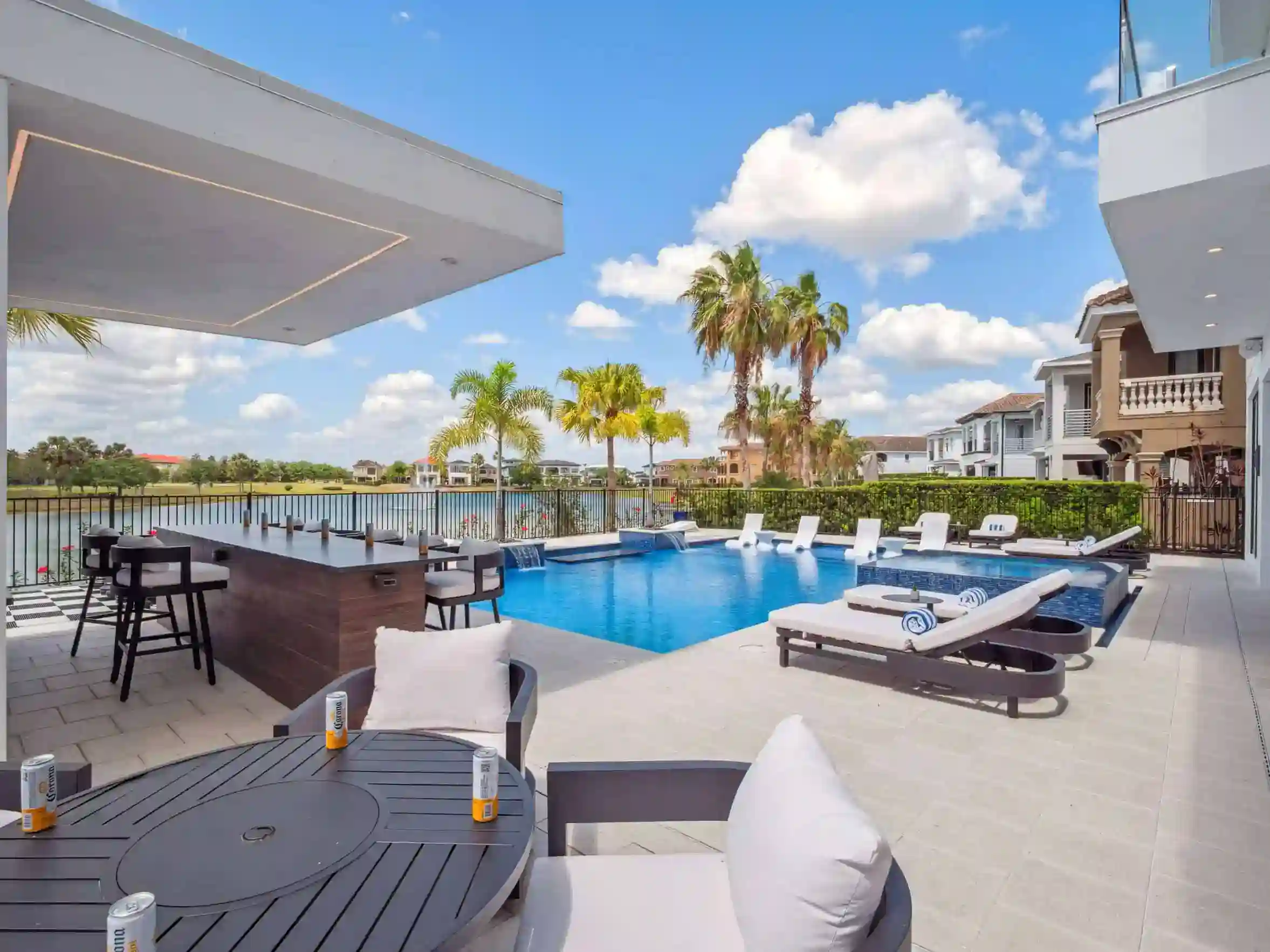 Outdoor pool area with lounge chairs, lush landscaping, and water views in Downtown Titusville