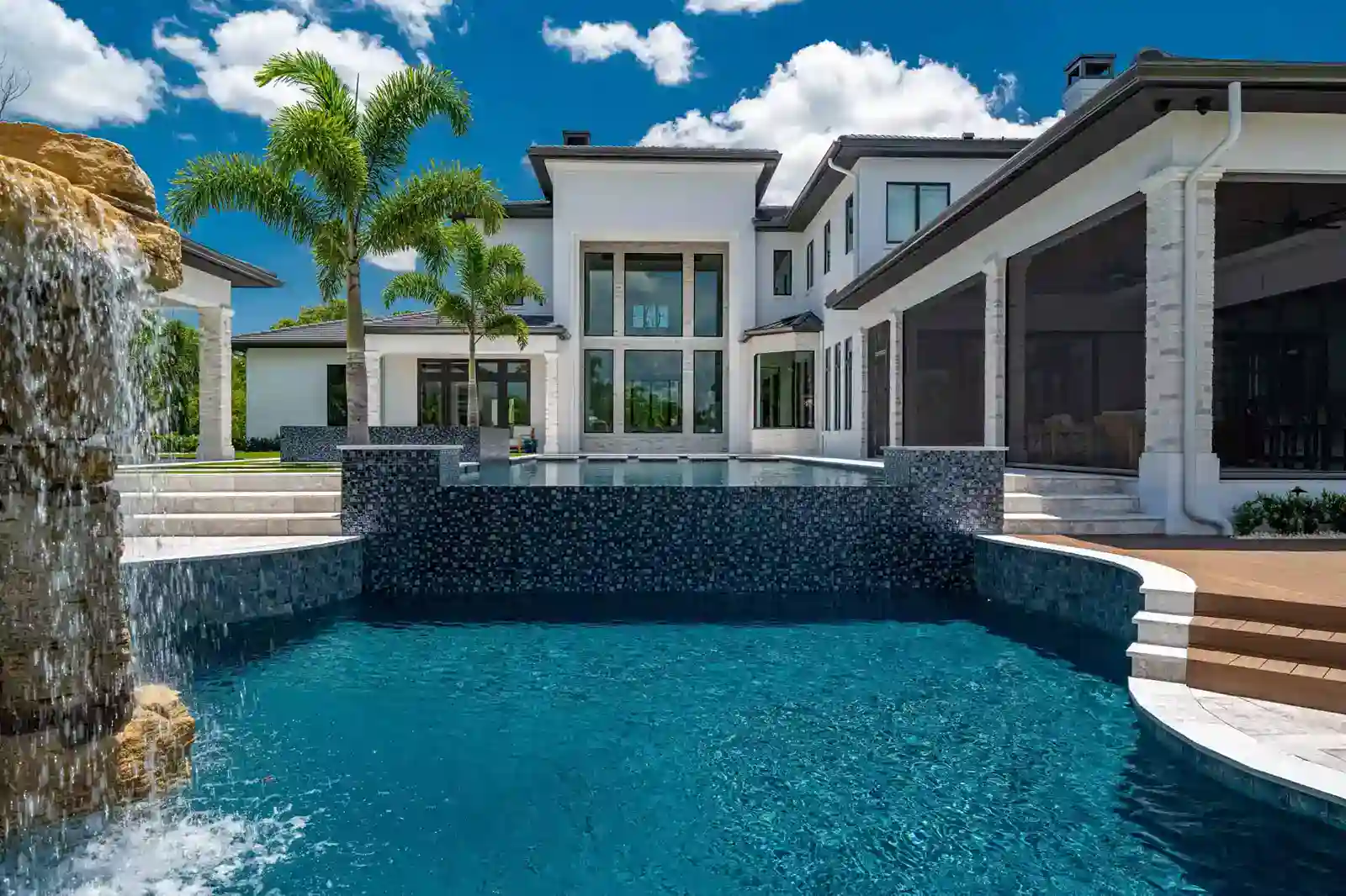 Luxury modern backyard pool with hot tub, lounge area, and palm tree design. Stunning modern luxury outdoor pool with stylish lounge areas and fire features.