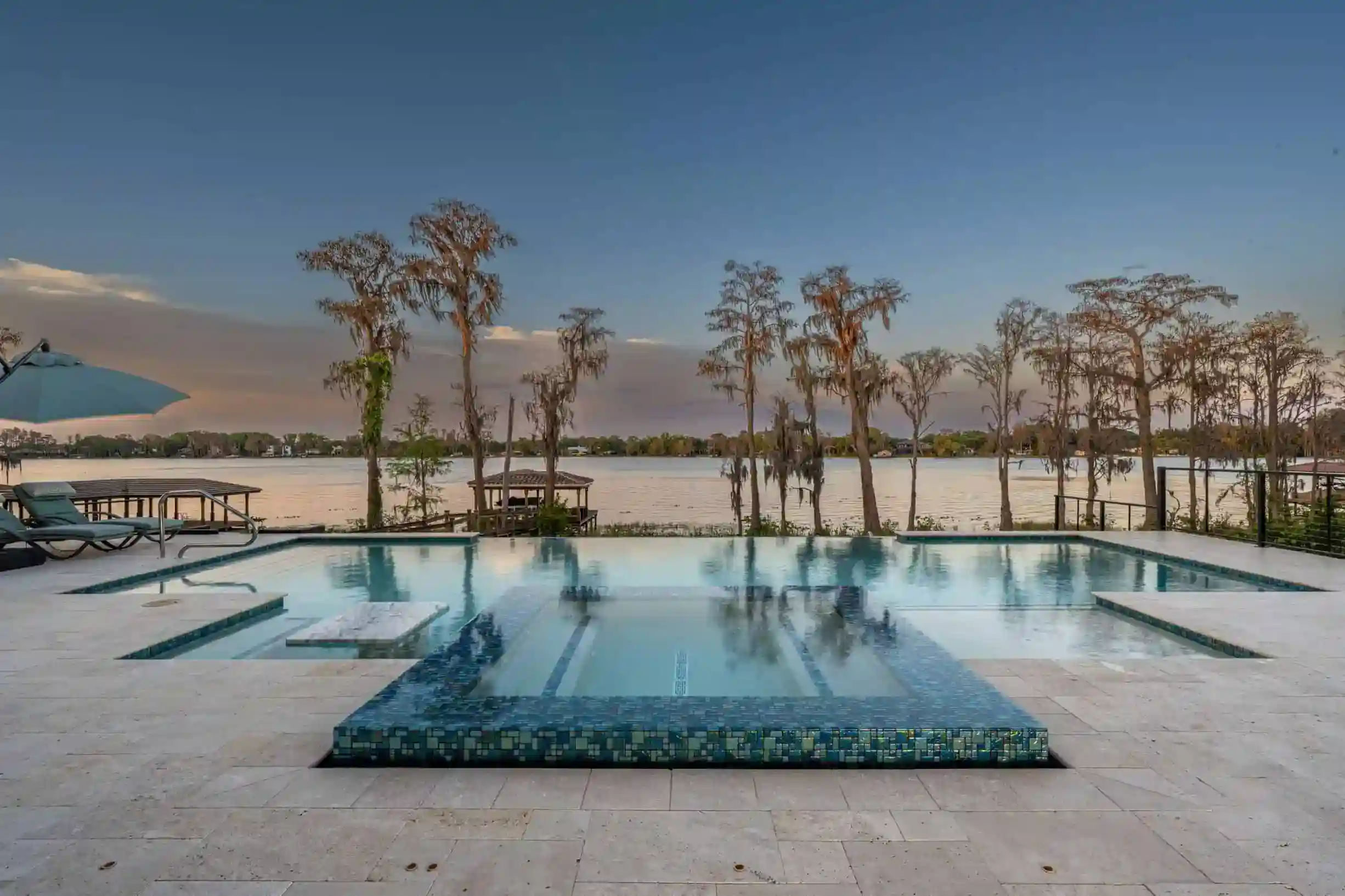 Luxury custom pool with modern design and tropical landscaping, perfect for upscale outdoor living. Stunning modern luxury outdoor pool with stylish lounge areas and fire features.