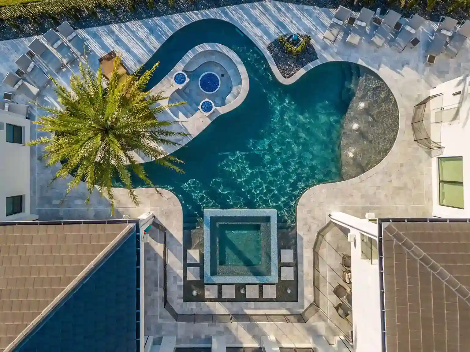 Luxurious custom-designed backyard pool with spa, fountain, and modern landscape features in North Beach Area, New Smyrna Beach