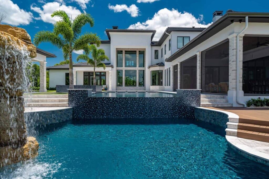 Luxury lagoon pool design with a natural rock waterfall in a Central Florida backyard
